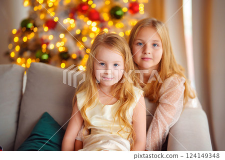 Two cute sisters in the New Year's decor of the room. 124149348