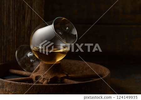 Cognac in snifter on old rusty wheel. 124149935