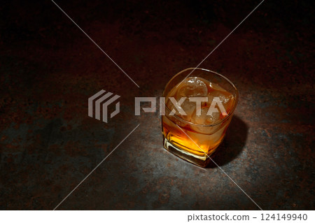 Whiskey in a square glass with ice on a vintage background. 124149940