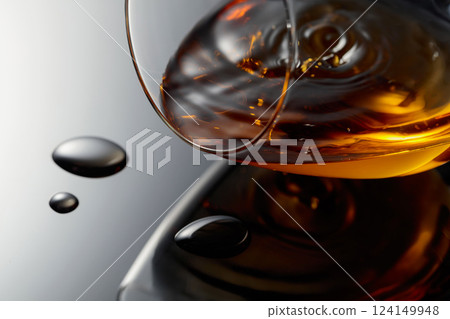 Glass of brandy on a black reflective background. 124149948