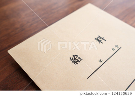 Pay envelope placed on a wooden table Pay envelope placed on a wooden table 124150639