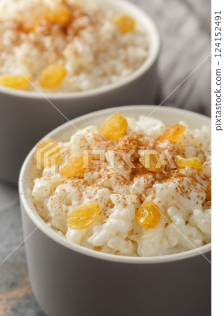 Old-Fashioned Rice Pudding is so creamy with the perfect texture and sweetness closeup on the bowl. Vertical 124152491