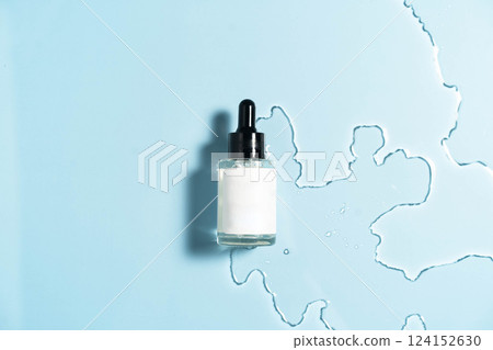 Hydrating serum on a calm blue background, enhanced by soft water droplets. 124152630