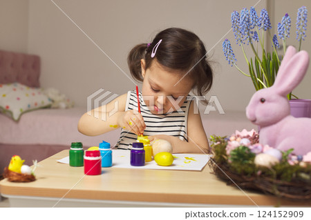 Little child girl paint Easter eggs at home. kid is preparing for Easter. Little child girl paint Easter eggs at home. kid is preparing for Easter. 124152909