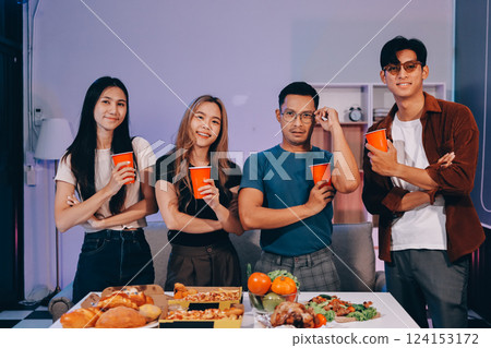 Happy young friends group having lunch at home. Asia family party eating pizza food and laughing enjoying meal while sitting at dining table together at house. Celebration holiday and togetherness. 124153172