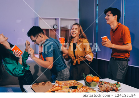 Happy young friends group having lunch at home. Asia family party eating pizza food and laughing enjoying meal while sitting at dining table together at house. Celebration holiday and togetherness. 124153184