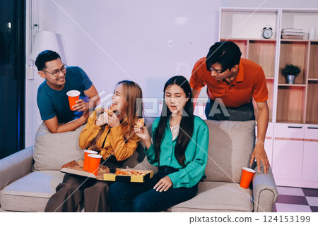 Happy young friends group having lunch at home. Asia family party eating pizza food and laughing enjoying meal while sitting at dining table together at house. Celebration holiday and togetherness. 124153199