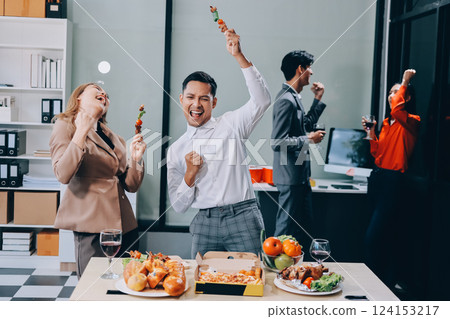 Asian office colleagues and friends enjoy a daytime BBQ with pizza and beer, celebrating Halloween and cheering for their favorite soccer team, creating a lively atmosphere filled with joy. Asian office colleagues and friends enjoy a daytime BBQ with pizza and beer, celebrating Halloween and cheering for their favorite soccer team, creating a lively atmosphere filled with joy. 124153217