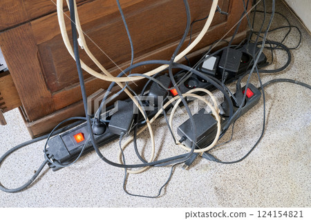 A Lot of messy cables on the floor near wooden desk 124154821