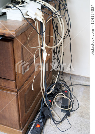 A Lot of messy cables on the floor near wooden desk A Lot of messy cables on the floor near wooden desk 124154824