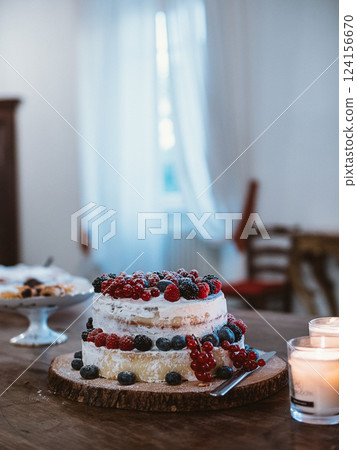 Rustic Berry Cake on Wooden Table with Candles 124156670