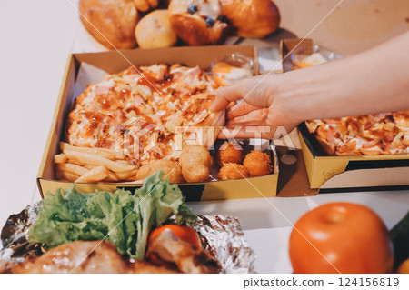 Happy young friends group having lunch at home. Asia family party eating pizza food and laughing enjoying meal while sitting at dining table together at house. Celebration holiday and togetherness. 124156819