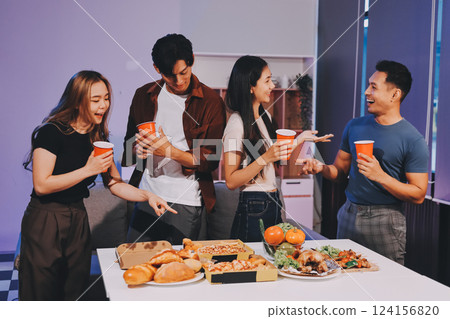 Happy young friends group having lunch at home. Asia family party eating pizza food and laughing enjoying meal while sitting at dining table together at house. Celebration holiday and togetherness. 124156820