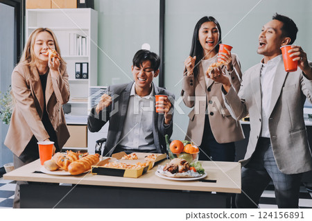 Asian office colleagues and friends enjoy a daytime BBQ with pizza and beer, celebrating Halloween and cheering for their favorite soccer team, creating a lively atmosphere filled with joy. Asian office colleagues and friends enjoy a daytime BBQ with pizza and beer, celebrating Halloween and cheering for their favorite soccer team, creating a lively atmosphere filled with joy. 124156891