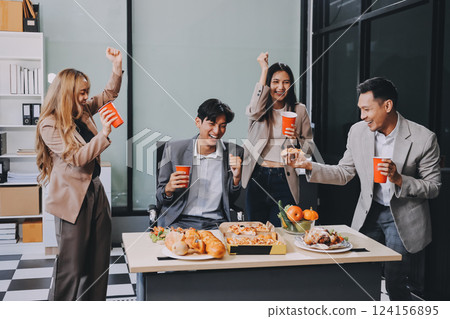 Asian office colleagues and friends enjoy a daytime BBQ with pizza and beer, celebrating Halloween and cheering for their favorite soccer team, creating a lively atmosphere filled with joy. Asian office colleagues and friends enjoy a daytime BBQ with pizza and beer, celebrating Halloween and cheering for their favorite soccer team, creating a lively atmosphere filled with joy. 124156895