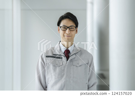 A man in his 40s wearing work clothes looking at the camera 124157020