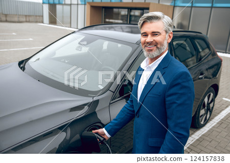 Businessman refilling car with fuel at the gas station 124157838
