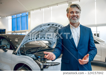 Businessman offering automobile repair and check up in workshop Businessman offering automobile repair and check up in workshop 124157842