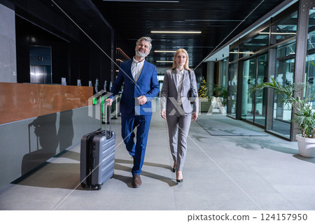 Business owner meeting a partner in the airport and going to the exit Business owner meeting a partner in the airport and going to the exit 124157950