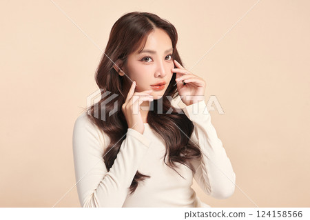 A beautiful young Asian woman with clean, fresh skin against a beige background. Skincare, facial treatment, cosmetology, beauty, and spa. An elegant portrait of an Asian woman. A beautiful young Asian woman with clean, fresh skin against a beige background. Skincare, facial treatment, cosmetology, beauty, and spa. An elegant portrait of an Asian woman. 124158566