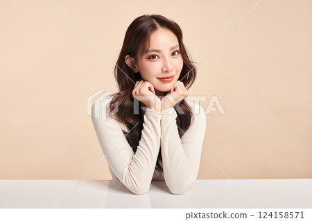 A beautiful young Asian woman with clean, fresh skin against a beige background. Skincare, facial treatment, cosmetology, beauty, and spa. An elegant portrait of an Asian woman. A beautiful young Asian woman with clean, fresh skin against a beige background. Skincare, facial treatment, cosmetology, beauty, and spa. An elegant portrait of an Asian woman. 124158571