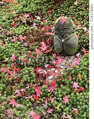 Jizo statue buried in fallen autumn leaves Jizo statue buried in fallen autumn leaves 124159063