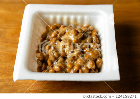 Sticky stringy white package of natto on a wooden table Sticky stringy white package of natto on a wooden table 124159271