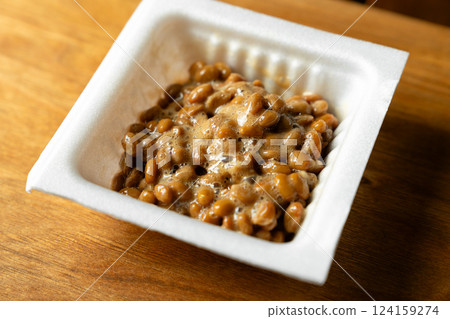 Sticky stringy white package of natto on a wooden table 124159274