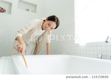 A woman cleaning a bath A woman cleaning a bath 124159699