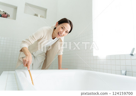 A woman cleaning a bath A woman cleaning a bath 124159700