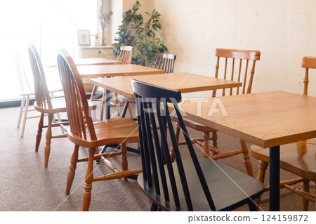 Dining tables lined up in a brightly lit room 124159872