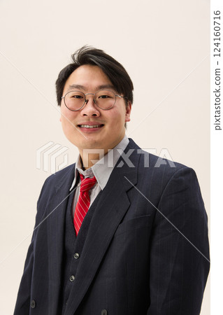 Portrait of young Asian man, professional dressed formal attire looking at camera with cheerful smile against white background. 124160716