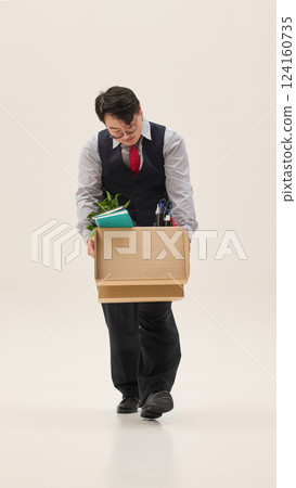 Sad Asian man unemployed, dressed formal attire, holding huge cardboard box with clothes against white background. Sad Asian man unemployed, dressed formal attire, holding huge cardboard box with clothes against white background. 124160735