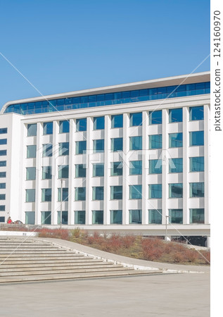 Modern White Building with Blue Windows, Sunny Day, Architectural Exterior, Urban Scene, Clear Sky. High quality photo Modern White Building with Blue Windows, Sunny Day, Architectural Exterior, Urban Scene, Clear Sky. High quality photo 124160970