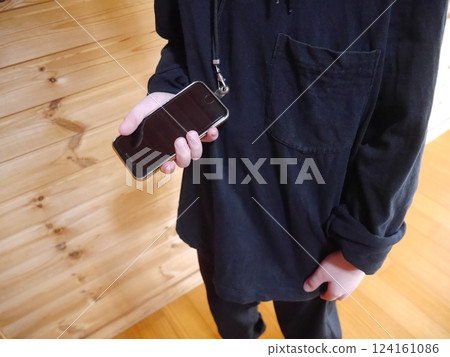 Child holding a smartphone while wearing a smartphone shoulder bag (no face) Child holding a smartphone while wearing a smartphone shoulder bag (no face) 124161086