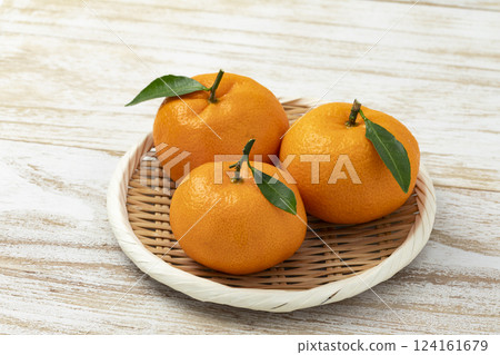 Mandarin oranges with leaves placed on white wood Mandarin oranges with leaves placed on white wood 124161679