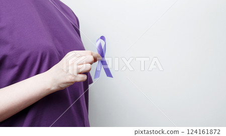 Purple ribbon held by a person in a purple shirt, symbol of support. Purple Epilepsy Awareness Day 124161872