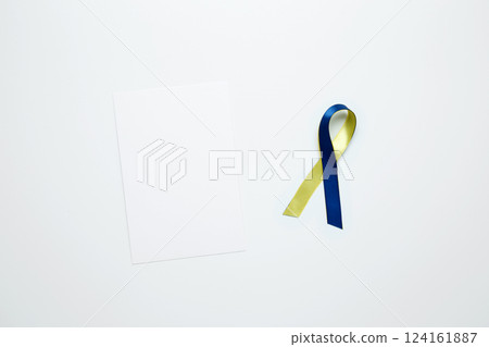 A yellow and blue awareness ribbon, symbolizing World Down Syndrome Day. White notebook mockup 124161887