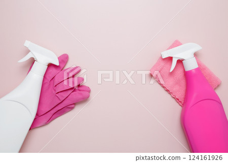 Pink cleaning supplies including rubber gloves, spray bottles, and microfiber cloths. Household cleaning and hygiene concept 124161926