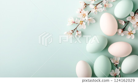 Pastel Easter eggs and delicate cherry blossoms are arranged on a soft pastel blue background, creating an elegant spring composition with copy space for design or text. 124162029