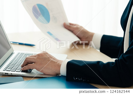 Businessman operating a personal computer 124162544
