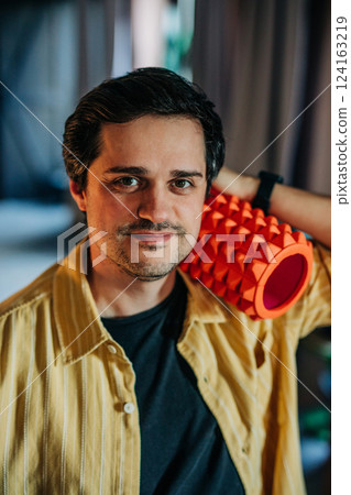 white European man in a yellow shirt is holding a ribbed conical massager at home white European man in a yellow shirt is holding a ribbed conical massager at home 124163219