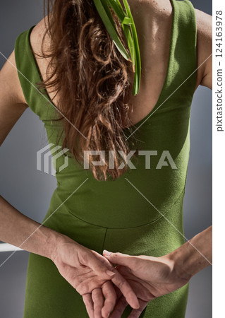 Elegant Woman in Green Dress with Natural Hair, Showing Stylish Back Pose, Fashion Concept 124163978