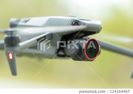 Drone quadcopter with digital camera and fast rotating propellers flying taking video and pictures 124164467