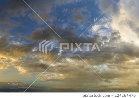 Dramatic sunset sky covered with colorful yellow clouds. Panoramic skyscape 124164476