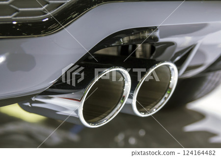 Double chrome exhaust pipe of powerful sport car with grey plastic details 124164482
