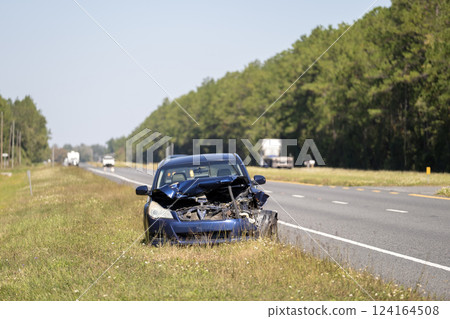 Dented car damaged after traffic accident parked on highway roadside. Transportation hazard concept 124164508