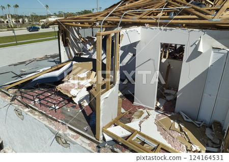 Consequences of natural disaster. Damaged house roof with missing shingles and broken apart walls after hurricane Ian in Florida Consequences of natural disaster. Damaged house roof with missing shingles and broken apart walls after hurricane Ian in Florida 124164531