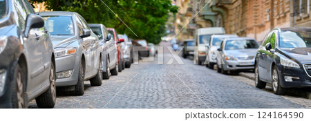 City traffic with cars parked in line on street side. City traffic with cars parked in line on street side. 124164590