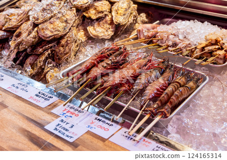 Selection of fresh seafood including skewered tiger prawns squid and scallops 124165314